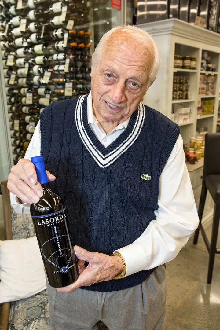 A man holding a bottle of wine in his hand.