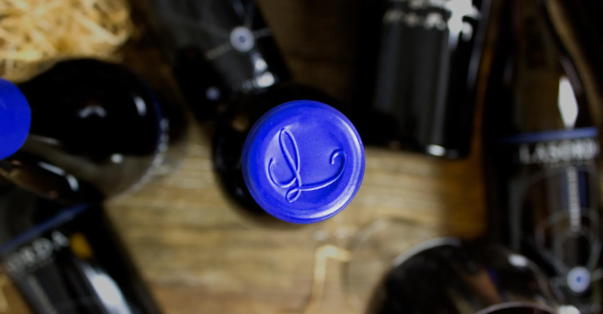 A blue bottle of wine sitting on top of a wooden floor.